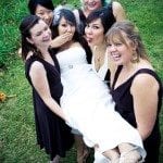 Bridesmaids hold bride up in green field at wedding ceremony in Nashville Tennessee