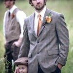 Groom stands with child in grassy field at wedding ceremony in Nashville Tennessee