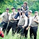 Groom on the shoulders of groomsmen in green field at wedding ceremony in Nashville Tennessee