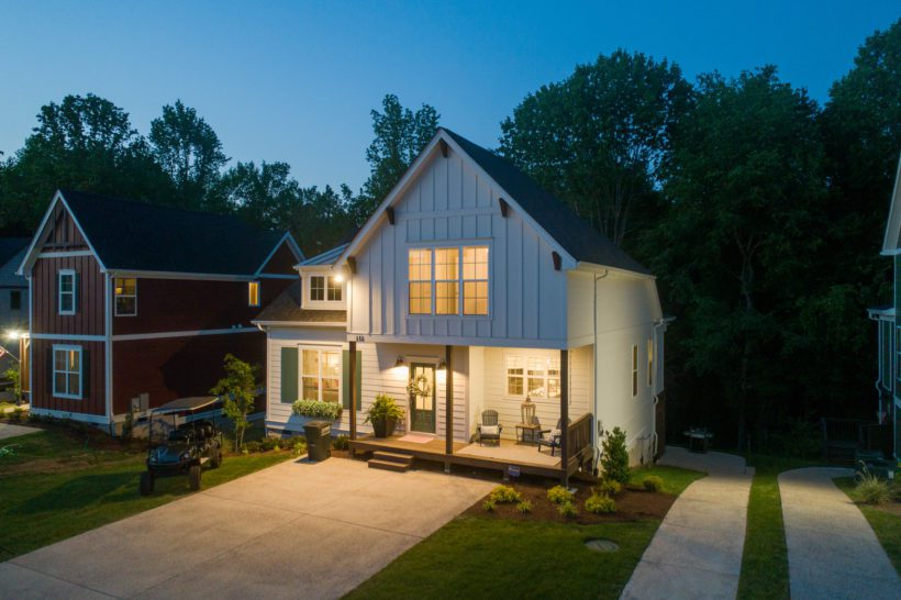 aerial photo of white lake house taken at night with glowing windows