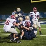 MBA football player drives forward with the football while defense piles on in Tennessee