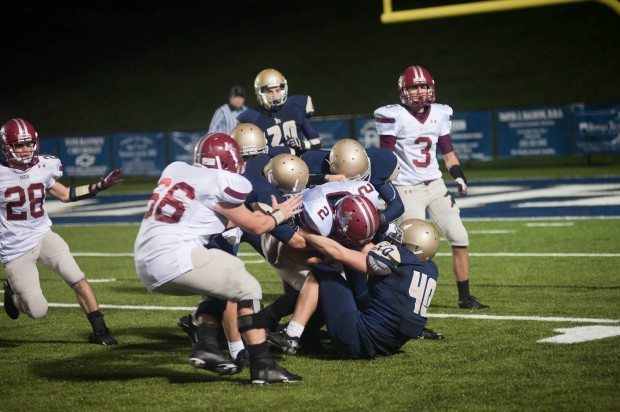 MBA football player drives forward with the football while defense piles on in Tennessee