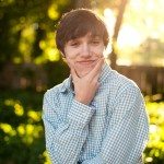 teen boy ponders outside in sunny yard in Tennessee