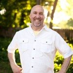smiling man in white shirt standing in sunny yard in Tennessee