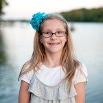 smiling girl with blue bow outside by lake in Tennessee