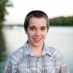 young boy smiles outside by lake in Tennessee