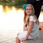 smiling young girl sits with feet in lake in Tennessee