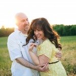 woman and man smile and embrace in sunny field in Tennessee