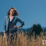 smiling girl in denim jacket smiles in sunny field in Tennessee