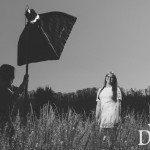 girl smiles in field while girl holds light in Tennessee