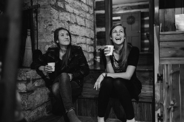 Bridesmaids sip coffee and laugh on wooden steps before wedding in Tennessee