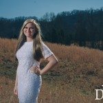 Young blonde girl in white dress standing in field in Tennessee