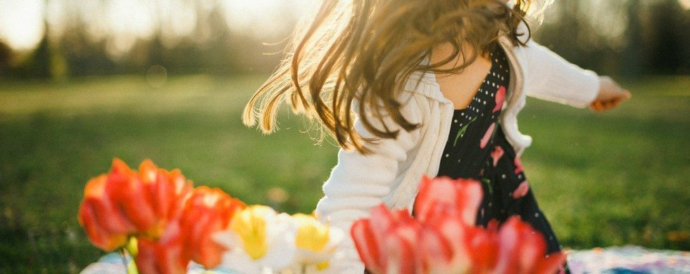 Child getting up from blanket outside with flowers in Tennessee