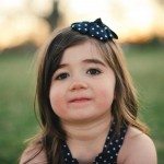 child with polka dot bow looks at camera in Tennessee