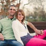 husband and wife smile and sit on bench outside in Tennessee