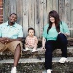 Couple smiles with baby on stone steps outside for portrait in Nashville Tennessee