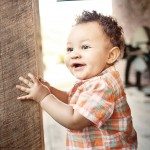 Cute smiling baby stands on wooden porch for portrait in Nashville Tennessee