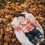 Smiling baby in woven wooden basket in autumn landscape for family portrait in Nashville Tennessee