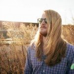 Band member in glasses stand in industrial area for portrait in Nashville Tennessee