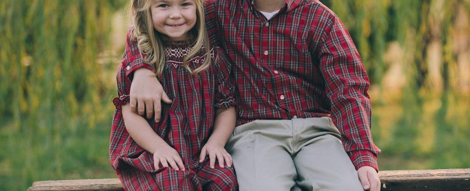 Brother and Sister seat on wooden bench by lake outside in Tennessee