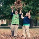 Couple laugh and throw leaves in the air during Autumn in Murfreesboro Tennessee