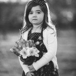child in dress holds flowers outside in Tennessee